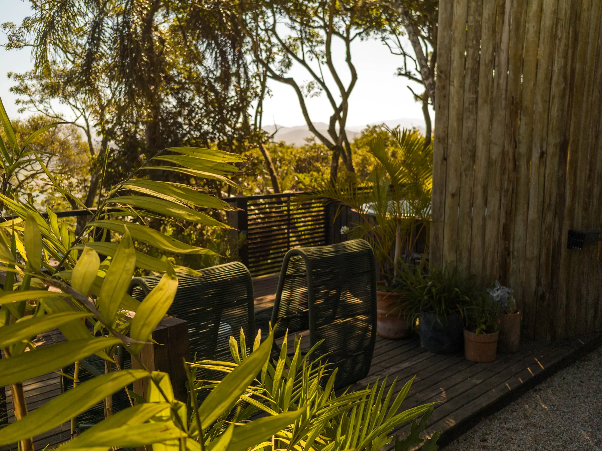Deck da Casa Atelier no fim da tarde, com vista para Ibiraquera e o mar