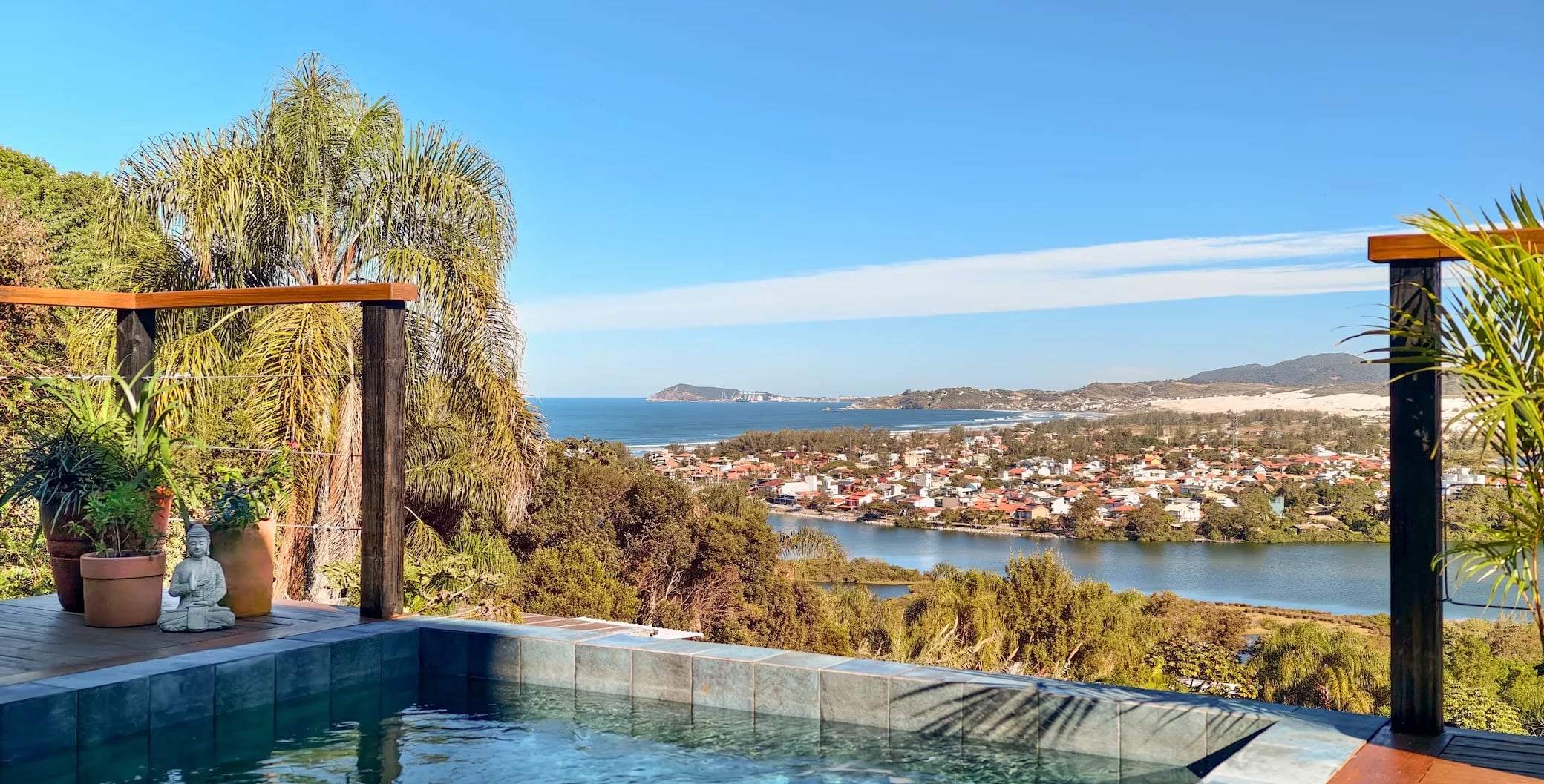 Piscina aquecida da Casa Galeria com vista para a Lagoa de Ibiraquera e o mar aberto ao fundo